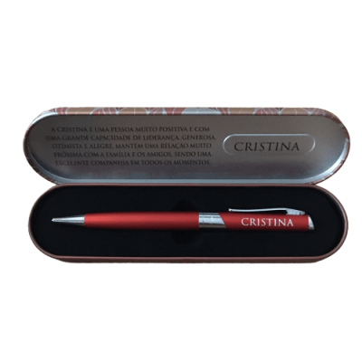 Caneta vermelha com nome Cristina numa caixa metálica com texto em português.