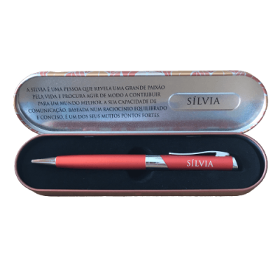 Conjunto de caneta vermelha com caixa metálica decorativa e texto sobre Sílvia.