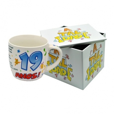 Caneca branca de cerâmica com a inscrição '19 ANOS!' e caixa decorativa com texto 'ATITUDE'.