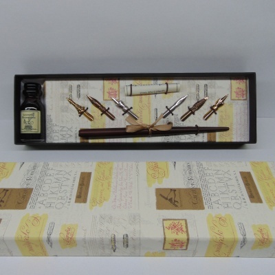 Conjunto de caligrafia com tinteiro, penas metálicas douradas e prateadas, suporte de madeira e tubo de pergaminho numa caixa estampada.