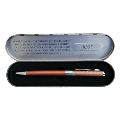 Estojo metálico aberto com caneta vermelha e texto sobre José no interior da tampa