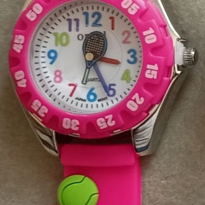 Relógio rosa com decoração de ténis e mostrador colorido.