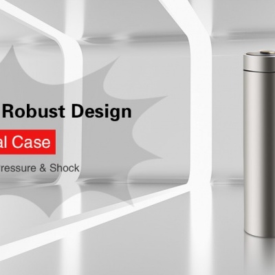 Objeto metálico cilíndrico prateado com texto promocional ao fundo