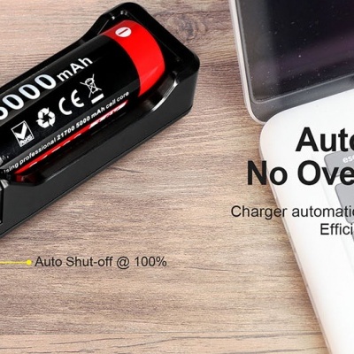 Carregador USB K1X com bateria 5000mAh em superfície de madeira ao lado de portátil