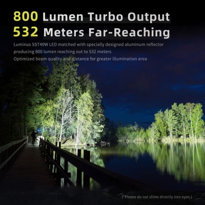 Iluminação noturna forte em ponte de madeira com texto informativo sobre luz