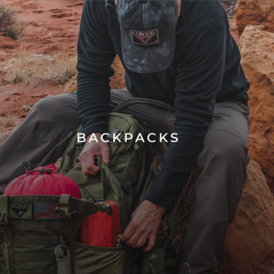 Mochilas verde e vermelha em ambiente árido com rochas e vegetação seca