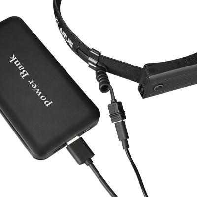 Banco de energia preto com texto Power Bank e bateria preta numa correia