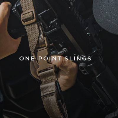 Pessoa segura arma preta com correia castanho claro e preto com texto ONE POINT SLINGS