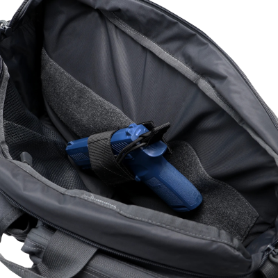 Interior de mala preta com objeto azul preso por cinta de velcro