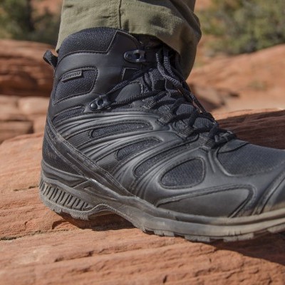 Bota de caminhada preta em terreno rochoso