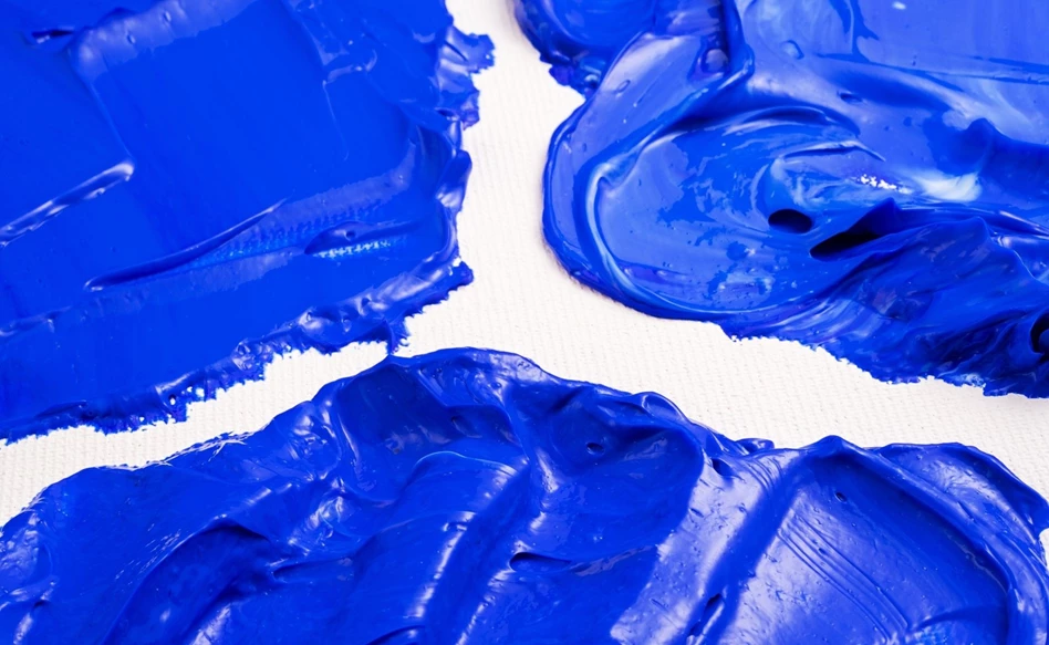 Tinta acrílica azul vibrante com textura espessa sobre fundo branco.