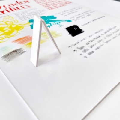 Documento com anotações coloridas e uma estrutura branca em forma de A sobre ele