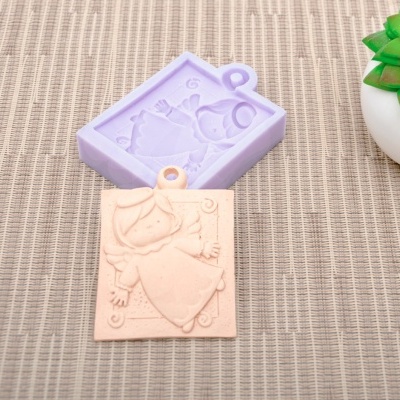 Molde de silicone lilás e peça de gesso com desenho de anjinho em tecido bege com planta suculenta
