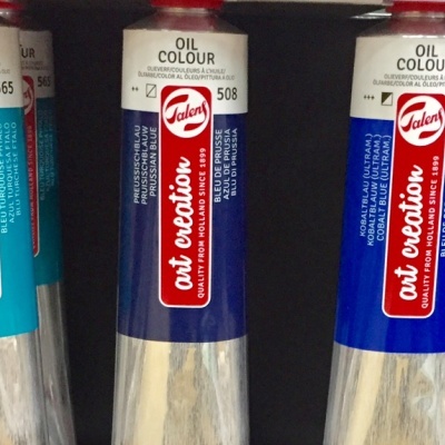 Tubos de tinta a óleo Art Creation em várias cores numa prateleira