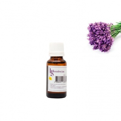 Garrafa de essência com uma tampa branca ao lado de flores roxas