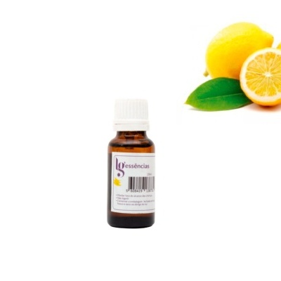 Frasco de essência junto a limões amarelos com folha verde