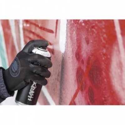 Mão com luva preta a segurar lata de spray preta com texto 'HARYA' a pulverizar tinta vermelha.