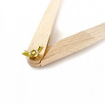 Compasso de madeira clara com peça metálica dourada