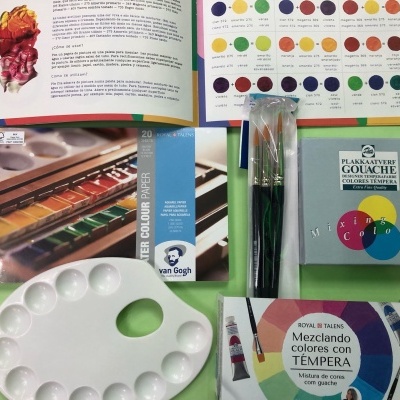 Materiais de pintura: paleta, pincéis, tintas gouache e livro com círculo de cores