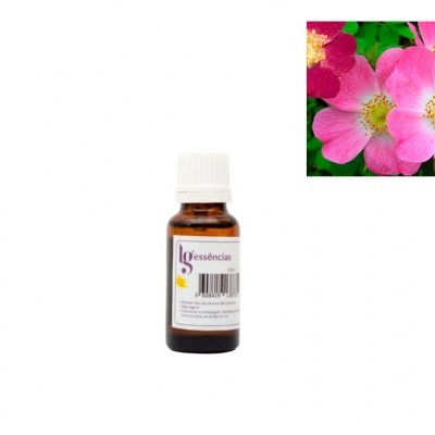 Frasco de essência com flores rosa e amarelas ao lado