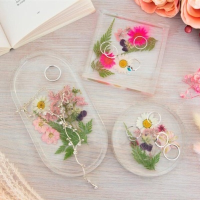 Tabuleiros de resina com flores prensadas e anéis prateados