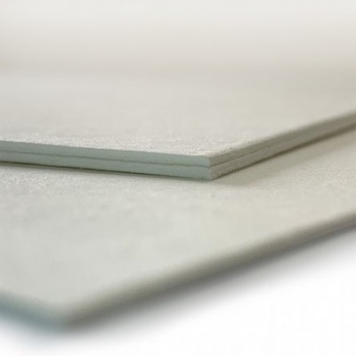 Placas retangulares cinza claro com textura lisa empilhadas em superfície branca