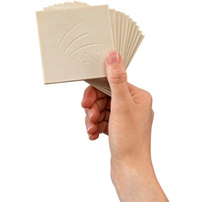 Conjunto de blocos quadrados bege numa mão sobre fundo branco