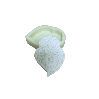 Molde de silicone bege com objeto branco em formato de folha com padrão floral