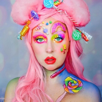 Mulher com cabelo rosa e maquiagem colorida temática de doces