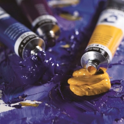 Tubos de tinta óleo roxa e amarela com tinta espessa na superfície de pintura