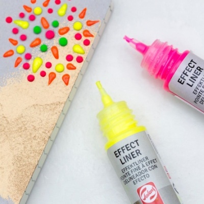 Tinta em tubo amarelo e rosa com padrão colorido aplicado em papel