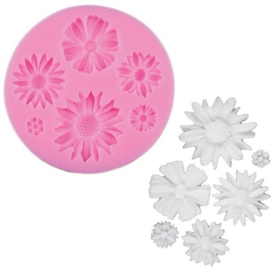 Forma de silicone rosa com flores moldadas brancas ao lado