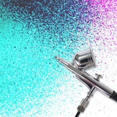 Aerógrafo prateado sobre fundo colorido azul, roxo e preto