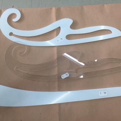 Conjunto de três réguas curvas para desenho em branco e transparente sobre papel castanho