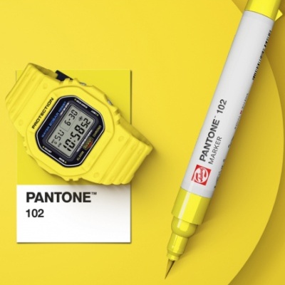 Relógio digital e marcador Pantone amarelos sobre fundo amarelo