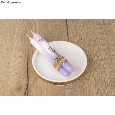 Duas velas lilás e branco amarradas num prato branco com borda castanha sobre madeira