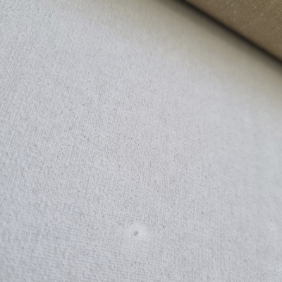 close-up de tecido branco texturizado com fundo castanho