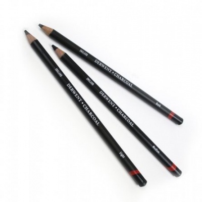 Três lápis de carvão Derwent pretos com detalhes em branco e vermelho sobre fundo branco