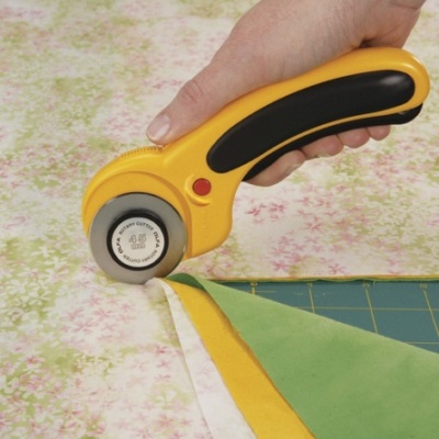 Roleta cortadora giratória amarela a cortar tecido com padrões florais