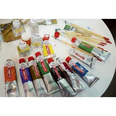 Tinta de óleo, pincéis e verniz sobre mesa branca