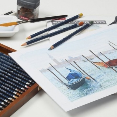 Lápis de cor, papel para aguarela com desenho de barcos e acessórios de pintura