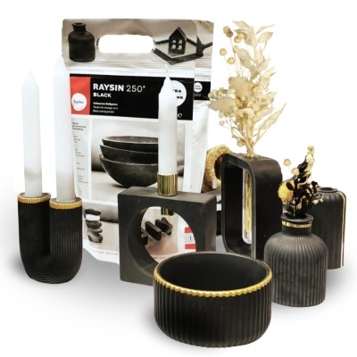 Acessórios decorativos pretos com detalhes dourados e velas brancas