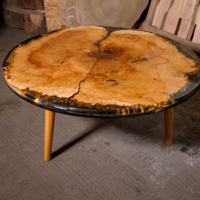 Mesa redonda com tampo de resina epóxi e madeira clara com pernas cilíndricas