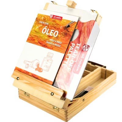 Estojos de pintura e livro sobre cavalete de madeira