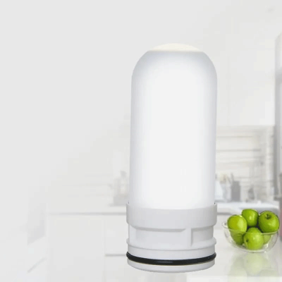 Filtro de água branco cilíndrico numa bancada de cozinha com tigela de maçãs verdes
