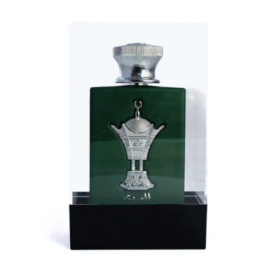 Frasco verde de perfume com tampa prateada e emblema metálico prateado na caixa transparente