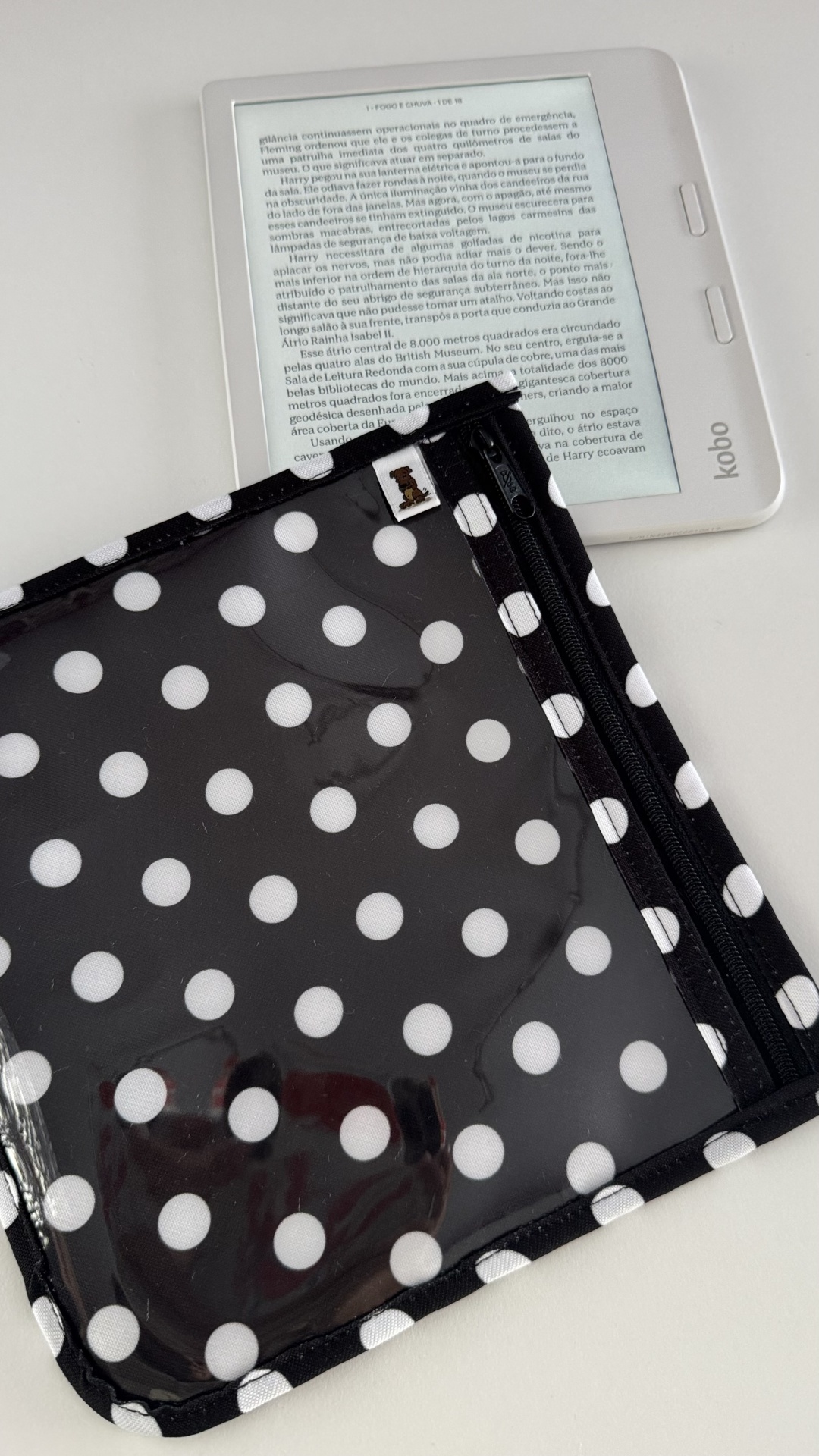 Leitor Kobo branco com capa protetora preta com bolinhas brancas.
