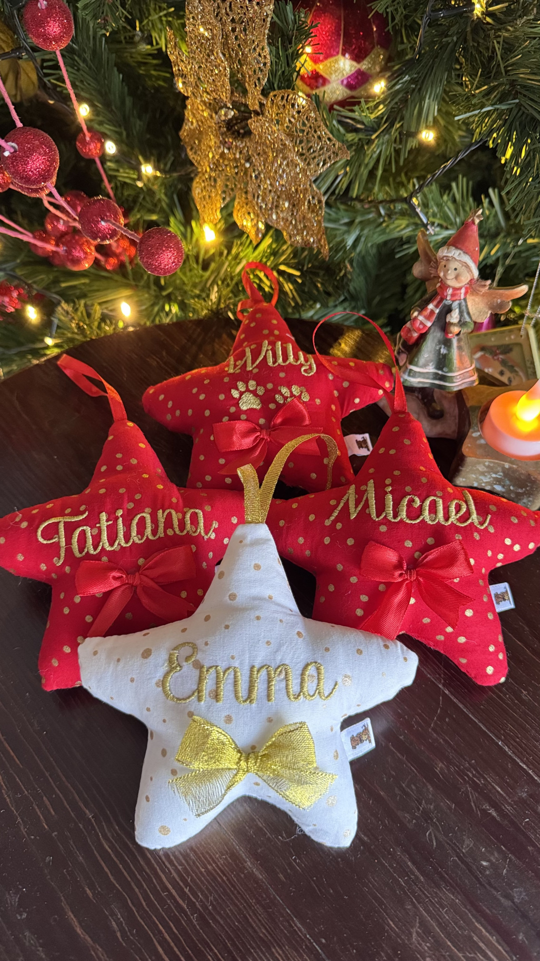 Estrelas de tecido vermelhas e branca com nomes bordados, laços e decoração de Natal
