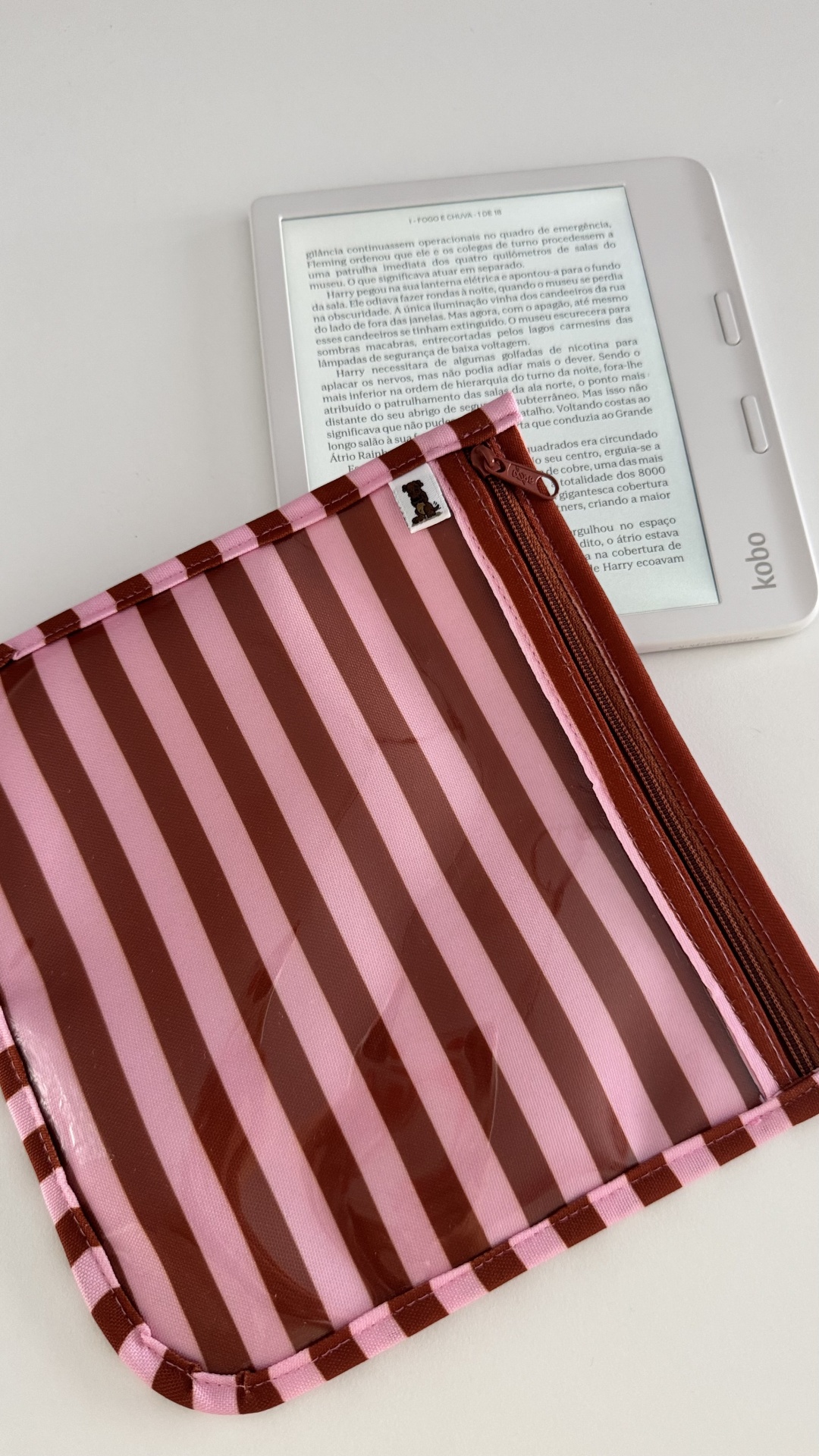 Capa transparente riscada rosa e castanho com fecho sobre leitor Kobo branco