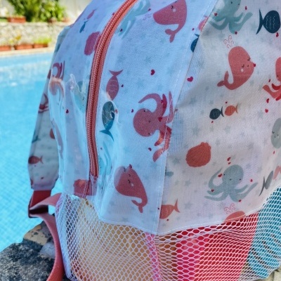 Mochila infantil com padrão de animais marinhos e bolso de malha junto à piscina